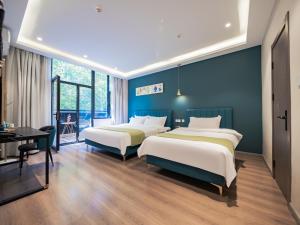 2 łóżka w pokoju z niebieskimi ścianami w obiekcie Wutong ins Designer Hotel w mieście Xi'an