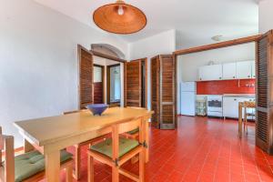 cocina y comedor con mesa de madera y sillas en Casa Palmaiola, en Cavo
