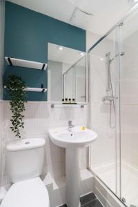 a bathroom with a toilet and a sink and a shower at Cotels - The Millhouse NEWLY REFURBISHED MODERN APARTMENTS WITH ULTRAFAST BROADBAND, FREE PARKING & A WORK DESK in Derby