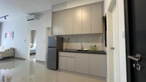 a kitchen with white cabinets and a black refrigerator at Cozy Studio Boulevard2 @ Kajang Town / 25-10 in Kajang