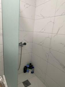 a bathroom with a shower with white marble tiles at Stan na dan Bratunac in Bratunac