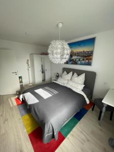 a bedroom with a large bed and a chandelier at Work & Stay Erlensee mit Stellplatz in Erlensee