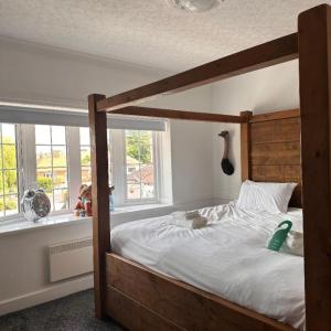 um quarto com uma cama grande e uma estrutura em madeira em Hatters Hotel em Skegness