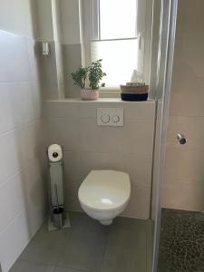 a small bathroom with a toilet and a window at Work & Stay Erlensee mit Stellplatz in Erlensee
