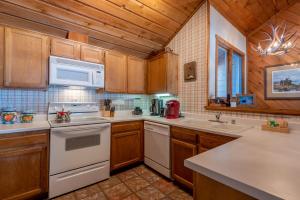 una cucina con elettrodomestici bianchi e armadietti in legno di Sunburst Condo 2749 On Golf Course with Mt Views and Elkhorn Amenities a Elkhorn Village