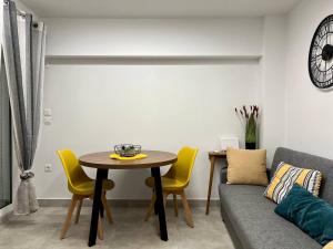 uma sala de estar com uma mesa e cadeiras amarelas em Attiki Apartment vipgreece em Atenas