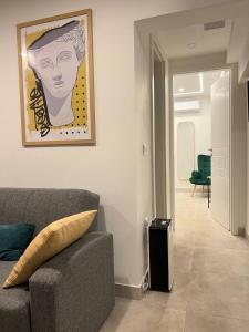 a living room with a couch and a painting on the wall at Attiki Apartment vipgreece in Athens