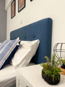 uma cama com uma cabeceira azul e duas almofadas em Attiki Apartment vipgreece em Atenas