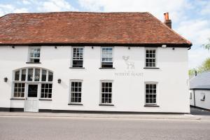 ein weißes Gebäude mit einem weißen Hutschild drauf. in der Unterkunft The White Hart, Overton in Overton