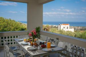 a table with food and a view of the ocean at Villa Panorama in Xirón Khoríon