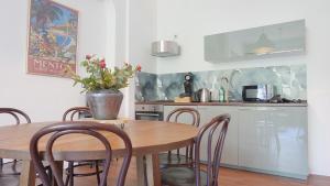 a kitchen with a wooden table and chairs and a kitchen with a counter at Heger Tor Apartments in Osnabrück