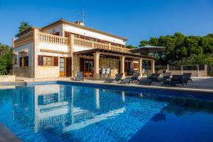 una villa con piscina frente a una casa en Villa Can Tosam Meiga, en Calas de Mallorca
