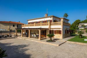 Una casa grande con un patio enfrente. en Villa Can Tosam Meiga, en Calas de Mallorca