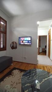 een woonkamer met een bank en een tv aan de muur bij Taksimde teraslı daire in Istanbul