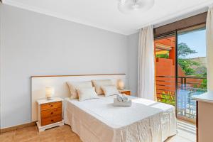 um quarto branco com uma cama e uma varanda em MEDANO4YOU Garden Xu em La Tejita