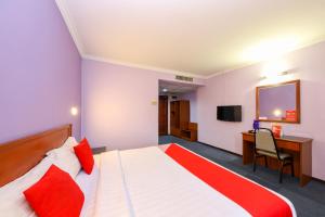 a bedroom with a bed and a desk and a television at Super OYO 473 Comfort Hotel 2 in Klang