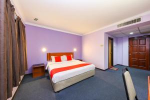a bedroom with a large bed and purple walls at Super OYO 473 Comfort Hotel 2 in Klang
