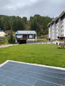 een veld met een gebouw met zonnepanelen op het gras bij Suite Neve in Madesimo