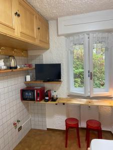 een keuken met twee rode krukken en een aanrecht met een raam bij Suite Neve in Madesimo