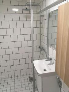 y baño blanco con lavabo y ducha. en Apartment in Tapiola, en Espoo