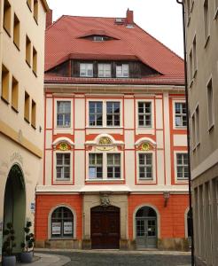 a building with a red roof and a brown door at Stadtpalais Romantik-Suite 3 Zimmer maximal 6 Personen in Bautzen