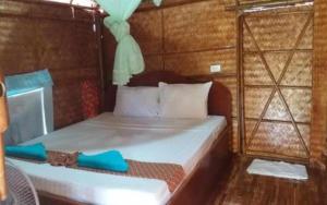 a bedroom with a bed with blue slippers on it at Lanta Long Beach Hostel in Ko Lanta