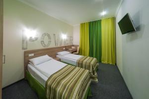 a hotel room with two beds and a television at Raziotel Kyiv (Boryspilska) in Kyiv
