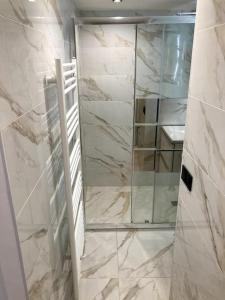 a bathroom with a shower with a mirror at 1650 Moriond - 2 Double Bedroom near Snow Front in Courchevel