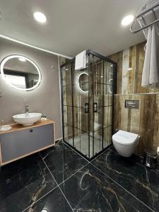 a bathroom with a shower and a sink and a toilet at Asgard Hotel in Beylikduzu
