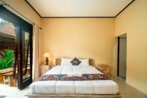 a bedroom with a bed and a large window at Pondok Lulik Homestay Canggu in Canggu