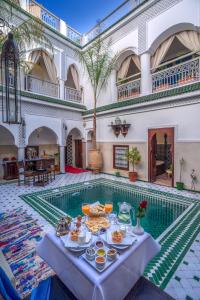 uma mesa com comida ao lado de uma piscina em Riad Al Madina Marrakech & Spa em Marraquexe