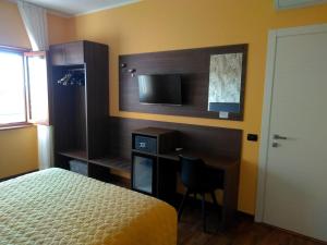 a bedroom with a bed and a desk and a television at House Volusia in La Giustiniana