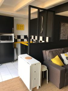 uma sala de estar com um sofá e uma cozinha em Au 29 logement cocon avec jacuzzi privatif em Longèves