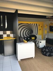 eine Küche mit weißen Schränken und einem Wandgemälde in der Unterkunft Au 29 logement cocon avec jacuzzi privatif in Longèves