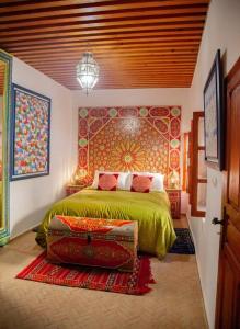 a bedroom with a bed with a green bedspread at Dar Mounia in Rabat