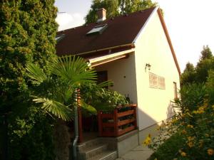 a small white house with a porch and plants at Sóstó Apartman in Siófok