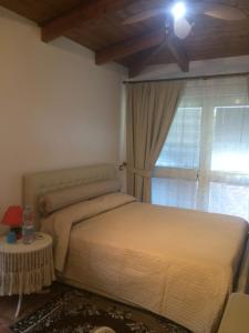 a bedroom with a bed with a ceiling fan and a window at L'Approdo 2 in Casalnuovo di Napoli