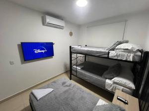 ヒラルドットにあるHermoso apartamento para descansar en familiaの二段ベッド2台、薄型テレビが備わる客室です。