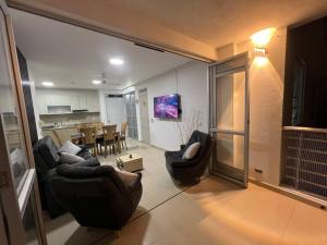 Hermoso apartamento para descansar en familia في جيراردو: غرفة معيشة مع كرسيين وغرفة طعام
