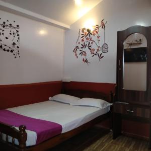 Schlafzimmer mit einem Bett und einem Spiegel in der Unterkunft HAVEN COTTAGE in Udagamandalam