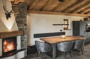 a dining room with a fireplace and a wooden table at Chalet BERGSUCHT in Ruhpolding Bayern, Traumlage am sonnigen Südhang, kostenlose Parkplätze, schnelles WLAN, ruhige Sackgasse, NETFLIX inklusive in Ruhpolding