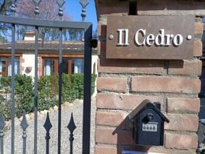 un cartello sul lato di un edificio con una cassetta della posta di La Limonaia Country House a Monteriggioni