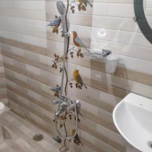 La salle de bains est pourvue d'un rideau de douche avec des oiseaux. dans l'établissement HAVEN COTTAGE, à Ooty