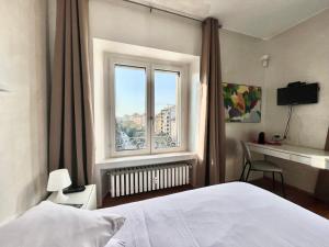 a bedroom with a white bed and a window at Tricolore Suite in Milan