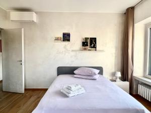a bedroom with a bed with white sheets at Tricolore Suite in Milan
