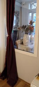 einen Vorhang in einem Zimmer mit Fenster und Vase in der Unterkunft 8 Rooms House in Balçova