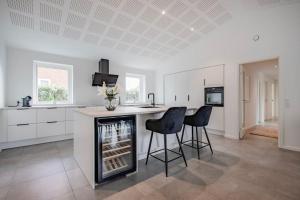 - une cuisine avec un bar avec deux chaises et un comptoir dans l'établissement Spacious family house, à Copenhague