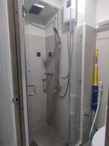 マニラにあるSchönes Apartment mit Pool-Nutzungのバスルーム(ガラス張りのシャワーブース付)