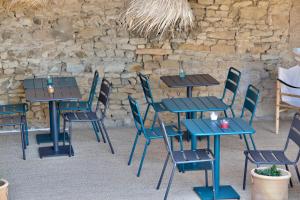 a group of tables and chairs in front of a stone wall at LE CLOS ZÉLIE in Pouilly-le-Monial