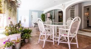 un patio con mesa de cristal y sillas en Villa Roc Guesthouse - Solar Power en Ballito